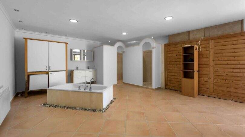 Geräumiger SPA-Bereich der Finca mit freistehender Badewanne, Holzsauna und Terrakottaboden in Cala Murada