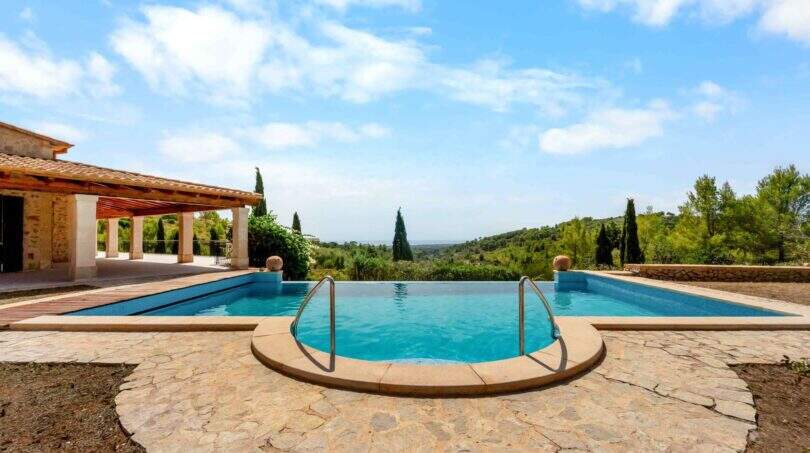 Infinity-Pool mit Natursteintetrasse und Meerblick der mallorquinischen Finca in Cala Murada