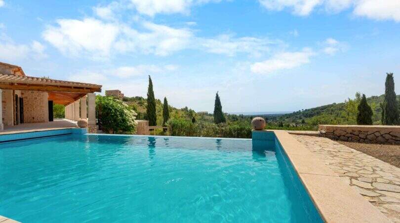 Infinity-Pool mit Meerblick, Natursteinteich und mallorquinischer Finca mit Pergola in Cala Murada
