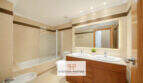 Helles Badezimmer der Erdgeschosswohnung Cala Antena mit Doppelwaschbecken, Badewanne und modernem Beleuchtungsspiegel.