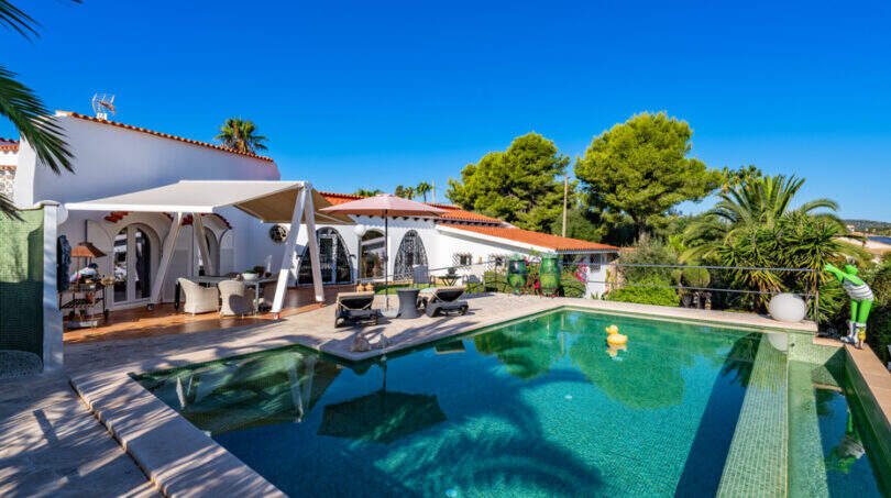 Outdoor area of the sea view villa in Cala Murada with turquoise pool, sun terrace and white Mediterranean architecture.