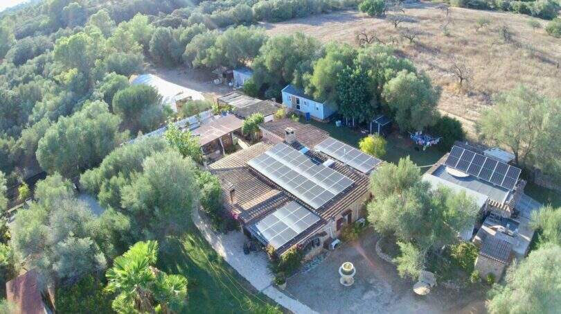Luftaufnahme der Finca Algaida mit Solaranlage auf dem Dach, umgeben von Olivenbäumen und weitläufigem Grundstück.