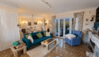 Helles Wohnzimmer der Mallorca-Villa mit blauem Sofa, Marmorkamin und Zugang zum Garten.