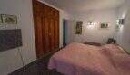 Schlafzimmer der Mallorca-Villa mit Doppelbett, Holzeinbauschrank und Wandleuchten in Llucmajor