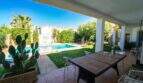 Überdachte Terrasse mit Esstisch, Pool und üppigem Garten der Villa in Llucmajor, Mallorca