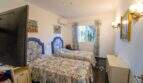 Helles Schlafzimmer der Mallorca-Villa mit zwei Einzelbetten, blauen Kopfteilen und Klimaanlage