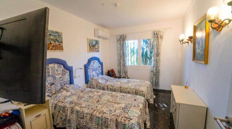 Helles Schlafzimmer der Mallorca-Villa mit zwei Einzelbetten, blauen Kopfteilen und Klimaanlage