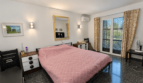Helles Schlafzimmer der Mallorca-Villa in Llucmajor mit Doppelbett, Klimaanlage und Balkonzugang.