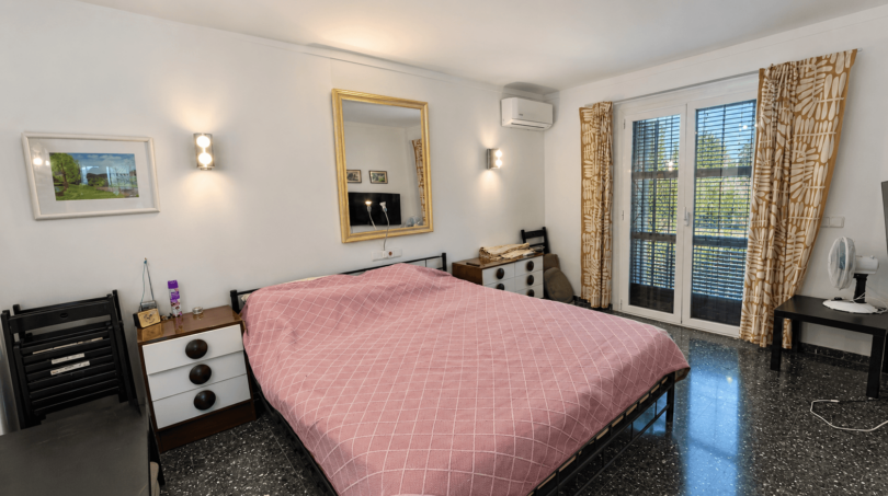 Helles Schlafzimmer der Mallorca-Villa in Llucmajor mit Doppelbett, Klimaanlage und Balkonzugang.