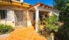 Eingang der Mallorca-Villa in Llucmajor mit Terrakottafliesen, Schmiedeeisengitter und üppigem Garten