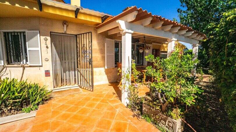 Eingang der Mallorca-Villa in Llucmajor mit Terrakottafliesen, Schmiedeeisengitter und üppigem Garten