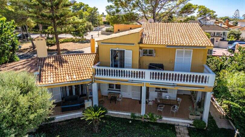 Luftaufnahme der mediterranen Villa in Llucmajor mit Terrakotta-Dach, Balkon und Terrasse umgeben von Pinien.