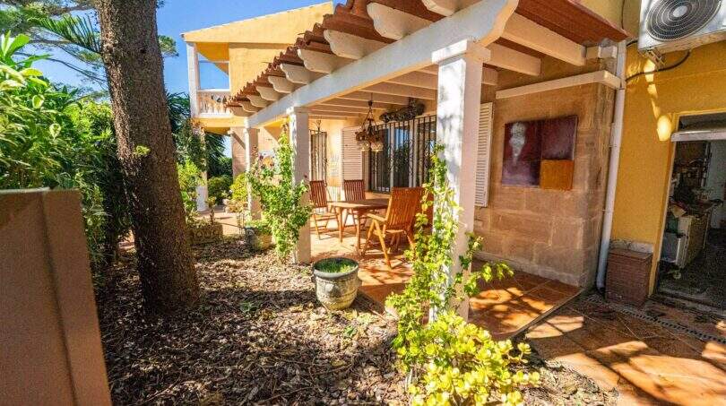 Überdachte Terrasse mit Holzmöbeln und begrüntem Garten der Villa in Llucmajor, Mallorca