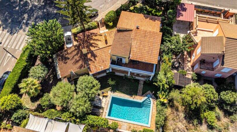 Luftaufnahme einer mediterranen Villa in Llucmajor mit pool, üppigem Garten und Terrakotta-Ziegeldach.