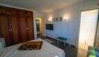 Geräumiges Schlafzimmer der Mallorca-Villa mit Holzeinbauschrank, Flachbild-TV und Zugang zur Terrasse