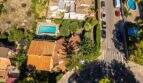 Luftaufnahme einer mediteranen Villa in Llucmajor mit Pool, Terrakottadach und üppigem Garten.