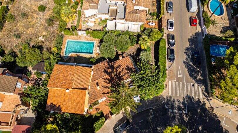 Luftaufnahme einer mediteranen Villa in Llucmajor mit Pool, Terrakottadach und üppigem Garten.
