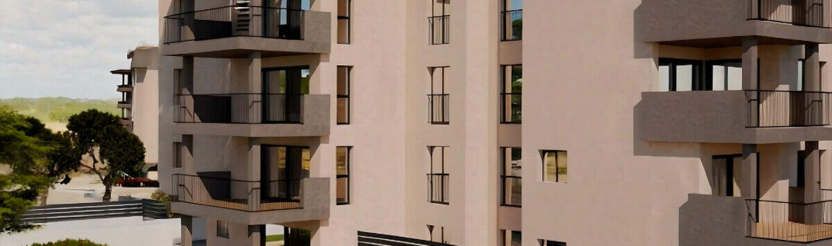 Außenansicht Penthouse-Anlage Cala Millor mit Pool, Balkonen und modernen Mehrfamilienhäusern in heller Fassade.