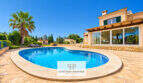 Finca Santa Maria: Pool mit Natursteintetrasse, mediterrane Villa mit Glasfront und Palmen im Sonnenschein