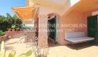 Terraza soleada con sofá lounge, toldo y cactus del apartamento de 4 habitaciones en Cala Millor