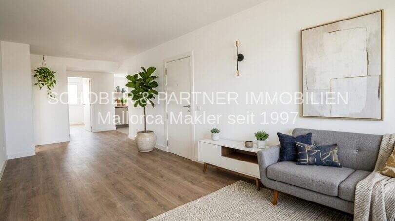 Área de estar clara del apartamento esquinero de nueva construcción en Cala Millor con suelo de madera, sofá gris y mobiliario moderno.