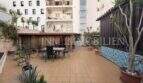 Große geflieste Terrasse mit Sitzbereich, Pergola und Palmen, umgeben von Wohngebäuden in Palma-City