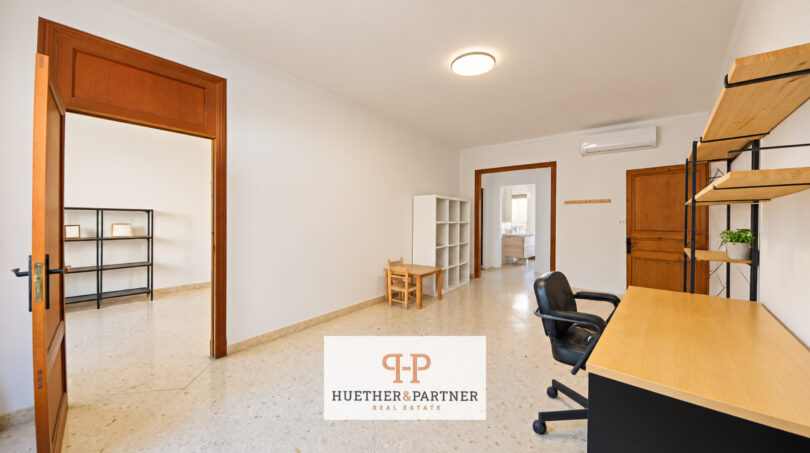 Helles Arbeitszimmer mit Schreibtisch, Regalwand, Klimaanlage und Terrazzoböden im Stadthaus Manacor