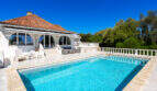 Außenpool mit Terrasse und weißer Villa mit Terrakotta-Dach in Cala Murada, umgeben von Grün