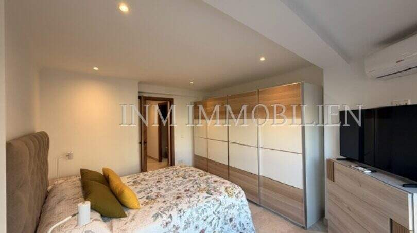 Helles Schlafzimmer mit Doppelbett, großem Einbauschrank und TV in möblierter Wohnung in Pere Garau, Palma