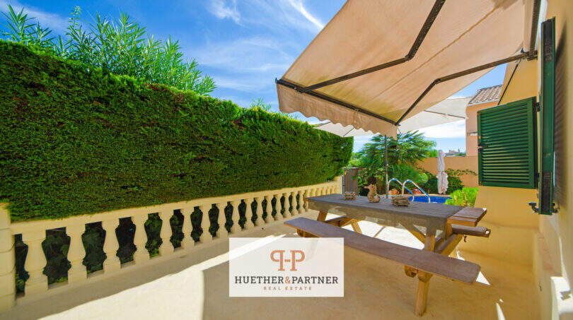 Sonnige Terrasse mit Markise, Picknicktisch und Heckenprivatsphäre des Hauses mit Pool in Cala Murada