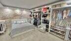 Helles Schlafzimmer mit Doppelbett, großem Ankleidezimmer und Blumentapete in Wohnung in El Arenal