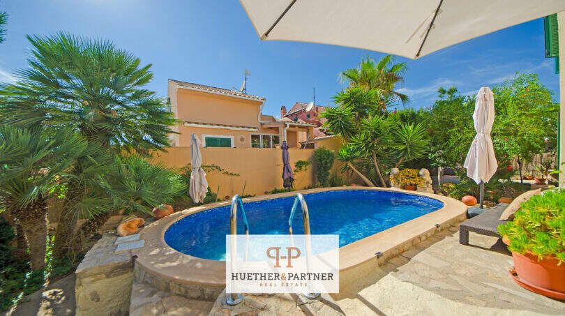 Ovaler Pool mit Natursteinumrandung, Sonnenschirme und mediterraner Bepflanzung am Ferienhaus in Cala Murada