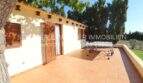 Sunny terrace with terracotta floor and table tennis table of a finca in Son Carrió, Mallorca.