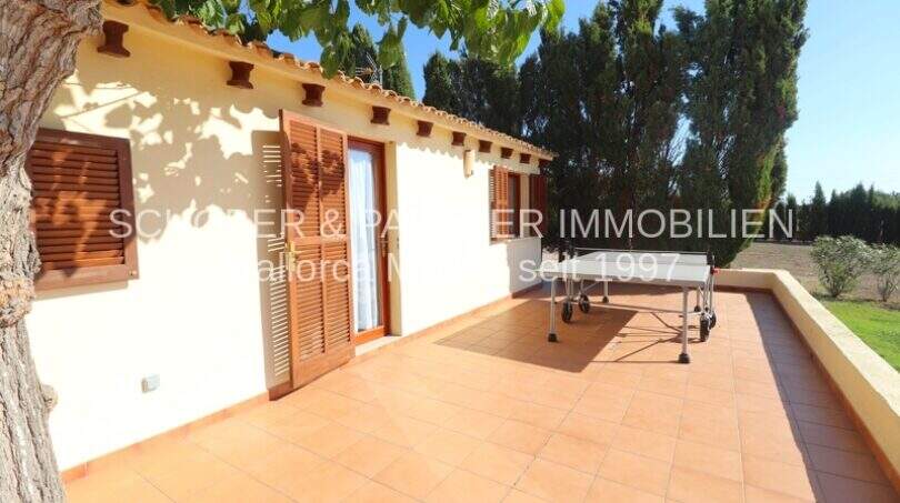 Sunny terrace with terracotta floor and table tennis table of a finca in Son Carrió, Mallorca.