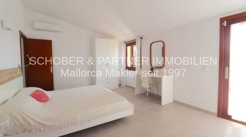 Bright master bedroom of the Mallorca finca with double bed, desk, wardrobe and terrace access.