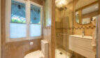Elegant bathroom of the sea view villa in Cala Murada with glass shower, washbasin and decorative leaded glass window.