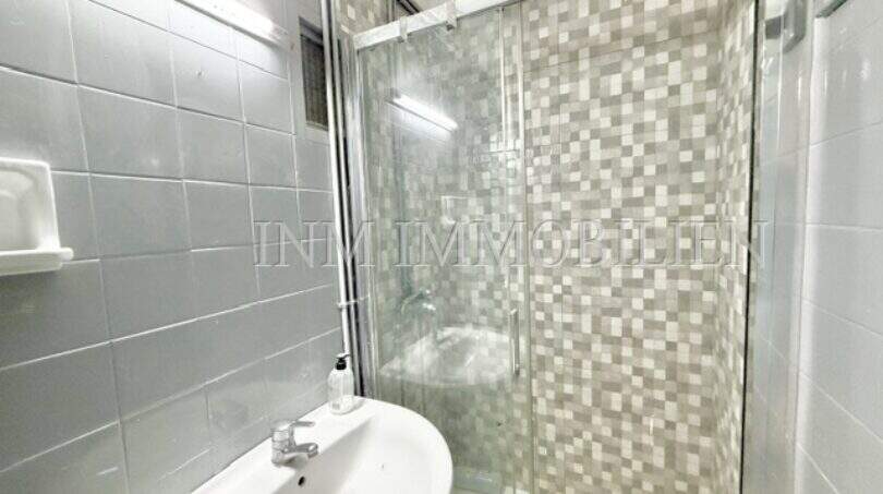 Bathroom with glass shower and sink, needing renovation, apartment Playa de Palma Mallorca