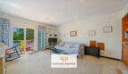 Luminoso salón del apartamento vacacional Porto Cristo con acceso al balcón, sofá, TV y vistas al mar