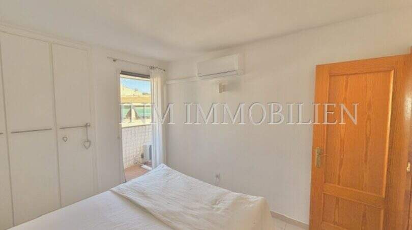 Helles Schlafzimmer mit weißem Einbauschrank, Klimaanlage und Zugang zu einem Balkon in Palmanova