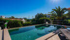 Infinity pool with turquoise water, palm trees and sea view of the villa in Cala Murada