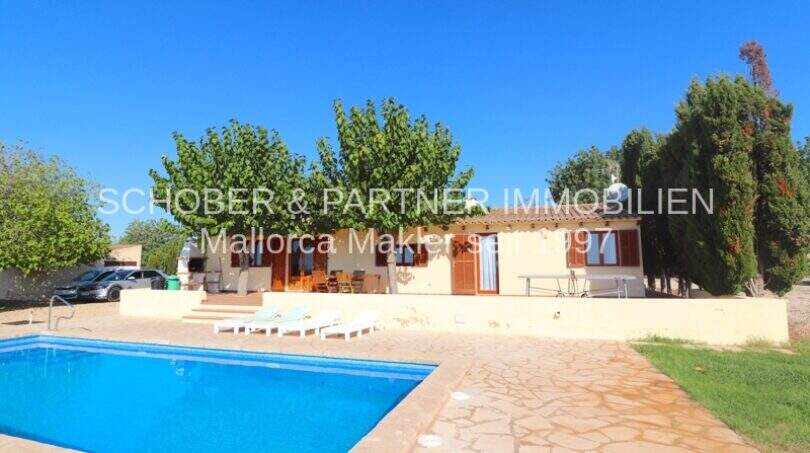 Exterior view Finca Son Carrió: Pool, terrace with sun loungers, Mediterranean garden and single-story country house.