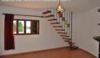 Helles Wohnzimmer der Finca Manacor mit Wendeltreppe, Terrakottaboden, Fenster und Hängelampe