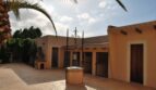 Gepflasterter Innenhof der Finca Manacor mit historischem Brunnen, mediterranen Nebengebäuden und Palme