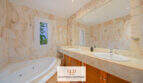 Marmorbad der Finca Santa Maria mit Whirlpool, Doppelwaschbecken und eleganter Steinverkleidung