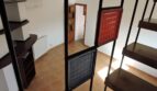 Treppenaufgang mit Metallgeländer und Glaspartition, Blick auf Wohnbereich mit Terrakottaboden und Heizkörper der Finca Manacor