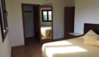 Helles Schlafzimmer der Finca Manacor mit Doppelbett, Wandspiegel, Einbauschrank und Terrakottaboden