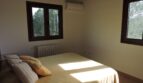 Helles Schlafzimmer der Finca Manacor mit Doppelbett, Klimaanlage, Heizkörper und Blick ins Grüne