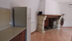 Küche der Finca Manacor mit Kühlschrank, Holztheke und rustikalem Steinkamin mit Holzbalken