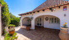 Überdachte EingangsTerrasse mit Rundbögen, Terrakottafliesen und mediterranem Garten der Poolvilla in Cala Murada.