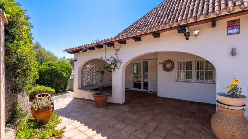 Überdachte EingangsTerrasse mit Rundbögen, Terrakottafliesen und mediterranem Garten der Poolvilla in Cala Murada.